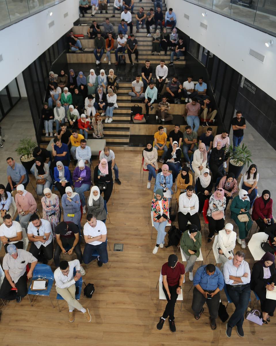 An audience filling the stepped seating for a talk