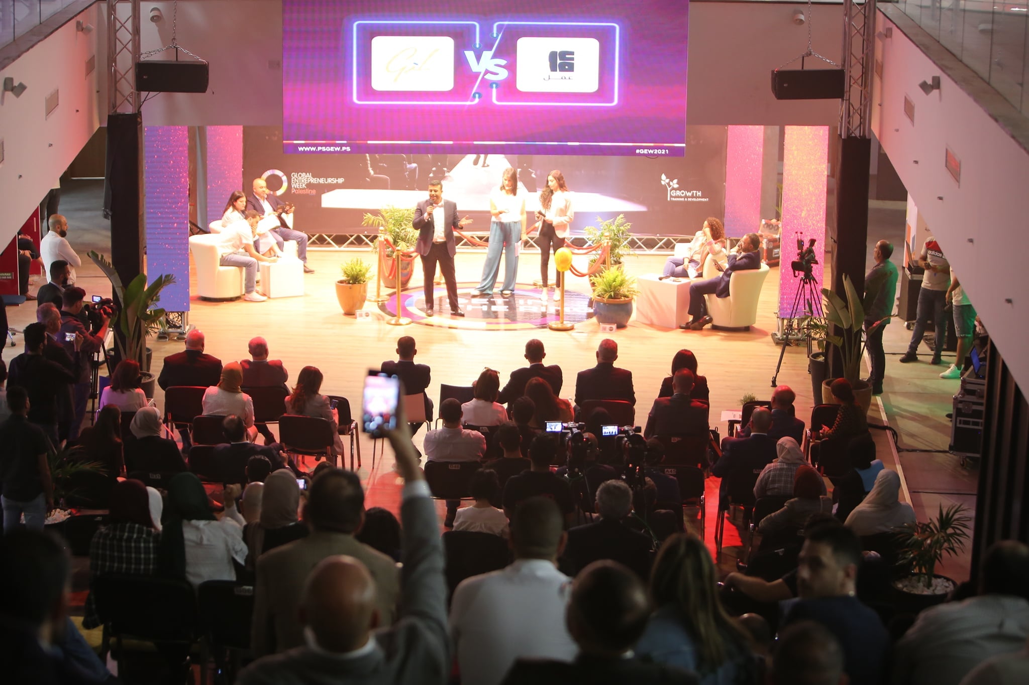 A full house watching a panel on the lit stage
