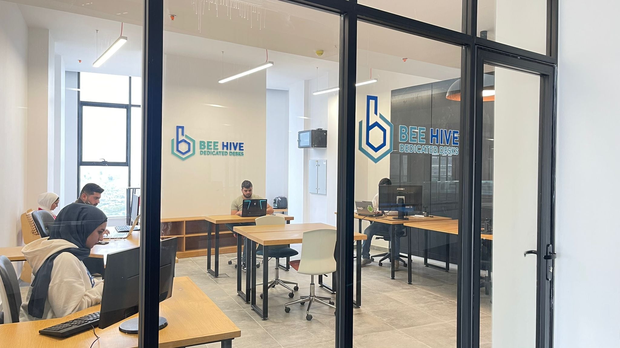 A glass-walled room inside the Beehive, set up with desks and task chairs