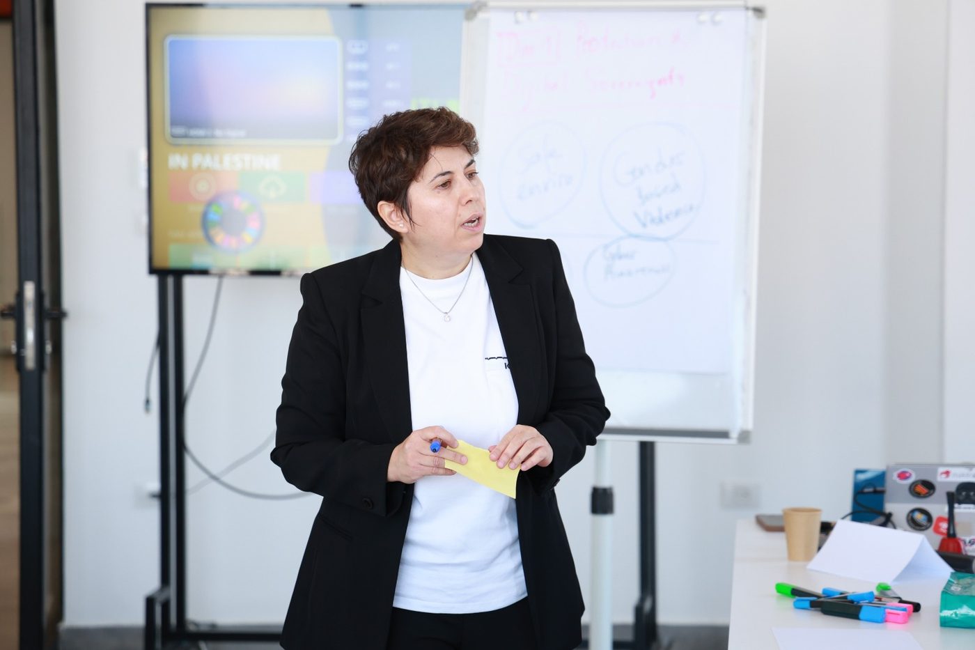 A facilitator presenting the first challenge area at the HerHack design thinking workshop