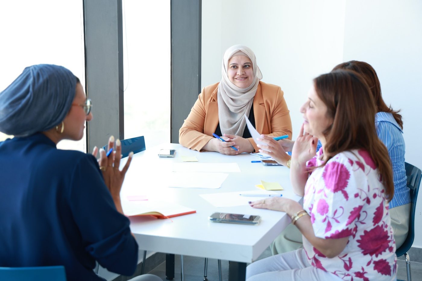 Participants in discussion around a table at the HerHack workshop